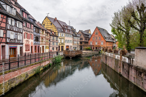 Fényképezés Vibrant timbered houses lining narrow canal, steep roofs and painted shutters mi