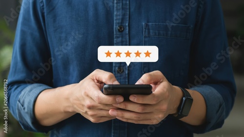 Person using a smartphone to give a five star rating for an excellent service review