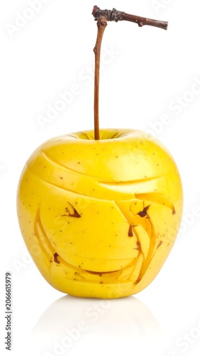 A carved yellow apple with a stem, isolated on white background