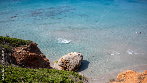 Aerial View of a Secluded Beach with Turquoise Water and a Sailboat