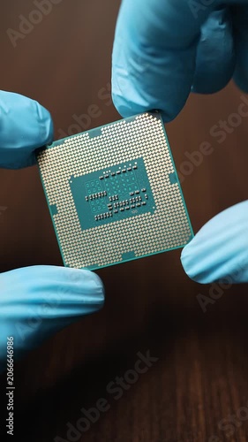 Close up view of hands in blue gloves holding CPU microchip module. Concept of global semiconductor shortage, high tech microelectronic component deficit and artificial intelligence development.