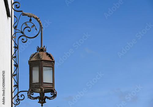 Ornate wrought iron lantern against a blue sky in Nerja Spain