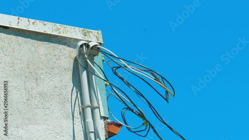 External building service mast with exposed electrical utility wiring
