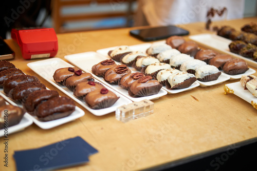 Tablou pe pânză Assorted Chocolate-Covered Dates on Display at a Gourmet Food Market