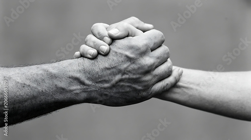 Black and white photo of two hands holding tightly in a strong supportive grip
