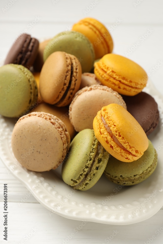 Fototapeta premium Different tasty macarons on white wooden table, closeup
