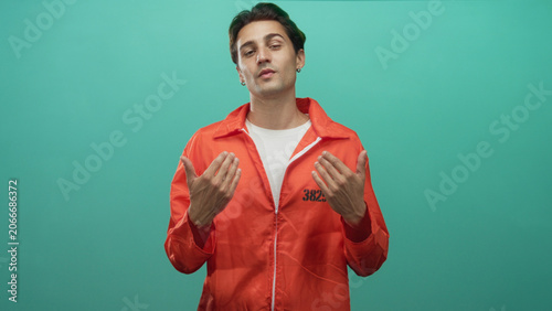 Foto Man in orange jumpsuit prisoner with hands open gesturing in a studio with visible inmate number; remorse reflection