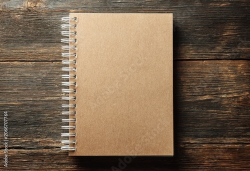 Top View of a Blank Kraft Paper Spiral Notebook on a Rustic Wooden Table.
