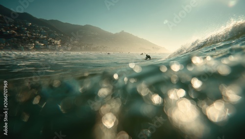 Surfer Riding a Wave in the Ocean with Sunlight Glinting on the Water.