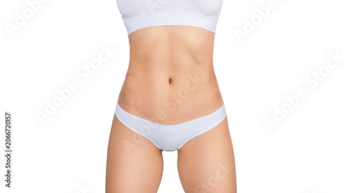 Slim and fit female faceless body in white base underwear with toned abdomen and hips isolated on white background.