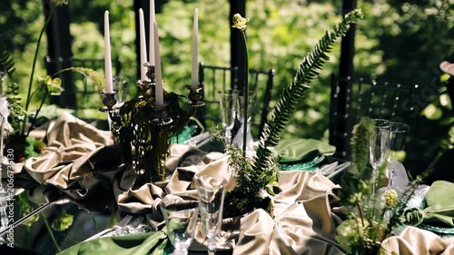 Glasses, candles in the stands and other decor on the table. Close-up shooting