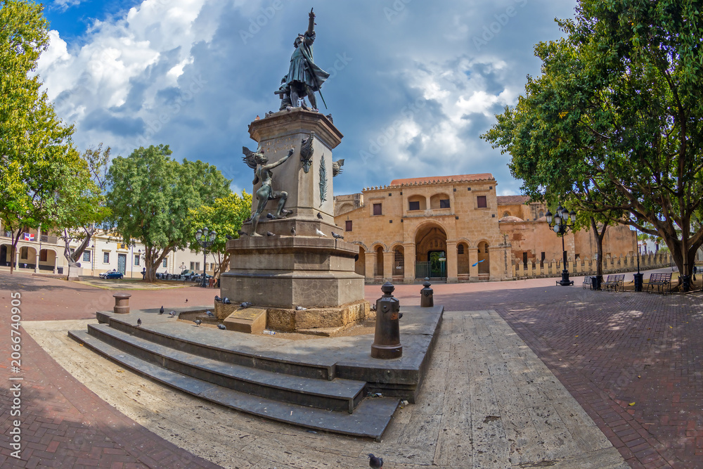 Obraz premium SANTO DOMINGO, DOMINICAN REPUBLIC-MARCH 13, 2020: Statue of Christopher Columbus in Parque Colon,the central square of the Ciudad Colonial historic district and the Catedral de Santa Maria la Menor.