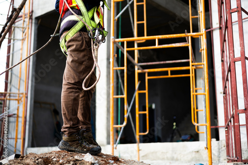 Canvastavla Close-up of construction worker wearing safety boots and harness at a building site