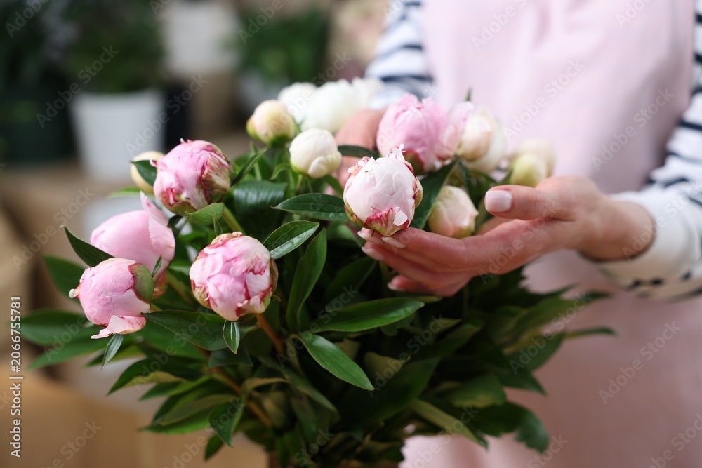 Fototapeta premium Florist with beautiful peonies in shop, closeup