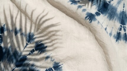 Close-up of tie-dye fabric with palm leaf shadow
