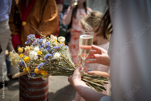 Le bouquet de fleur d'une mariée avec un verre de champagne à la main