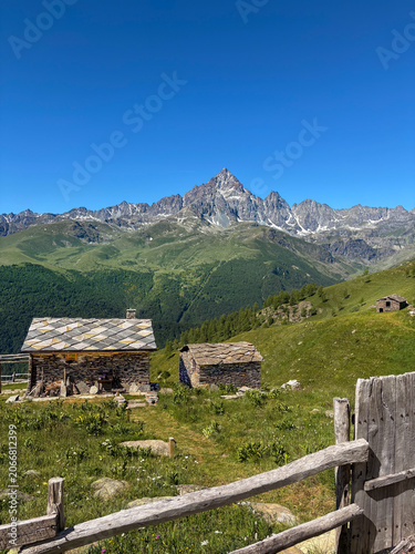 View of Monviso mountain peak (Cottian Alps), rising above traditional alpine stone houses, known as meire, Piedmont, Italy. 