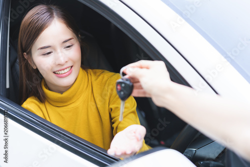 Business car rental, sell or buy service, dealership agent dealer sale hand giving auto key of vehicle to customer renter, buyer smile asian young woman receiving, client or tenant transfer automobile