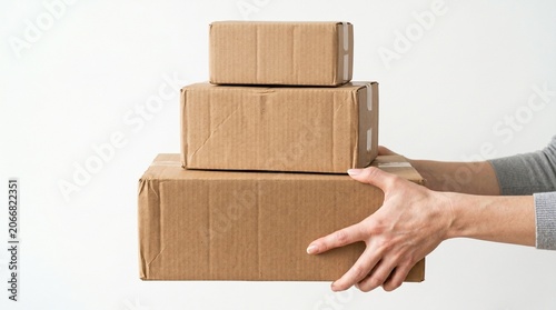 Person holding stacked cardboard boxes for shipping or storage