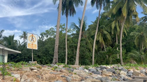 Private property sign against a background of palm trees and a blue sky