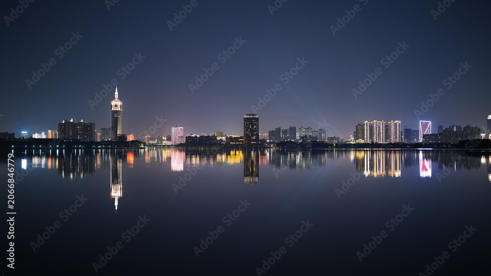 Fototapeta premium The night city view with the reflection in water at night