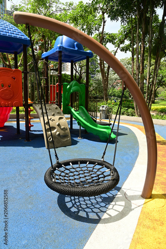 A type of playground equipment called a swing, where players sit on a net and swing back and forth in the park.