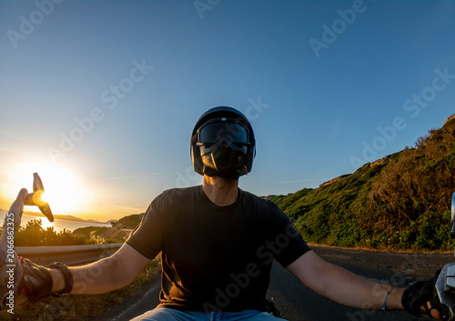 Handlebar POV Biker Riding Coastal Road at Sunset Backlit by the Sun