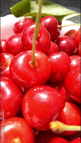 Close-up view of ripe red cherries in a white bowl. Fresh juicy summer fruit showcasing natural sweetness, vibrant color and healthy seasonal nutrition.