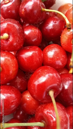 Close-up view of ripe red cherries in a white bowl. Fresh juicy summer fruit showcasing natural sweetness, vibrant color and healthy seasonal nutrition.
