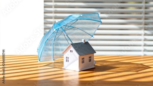 Miniature house under blue umbrella