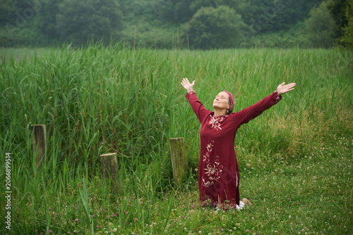 Woman kneeling, embracing nature and spiritual freedom