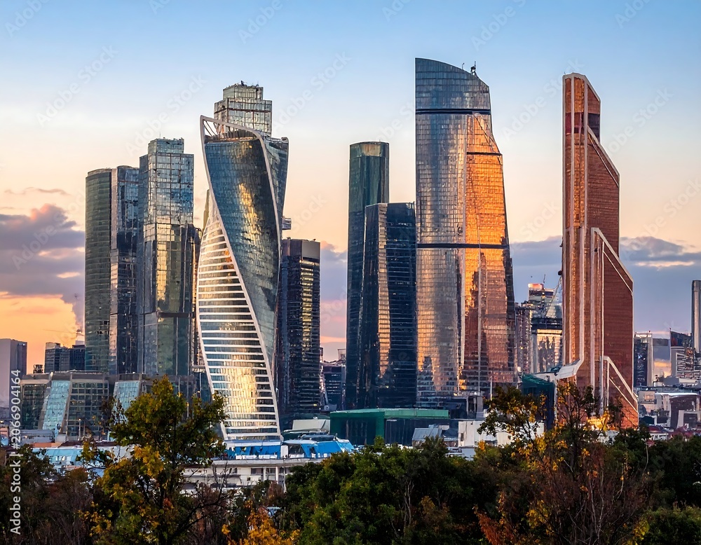 Obraz premium A cityscape at sunset featuring modern skyscrapers and trees