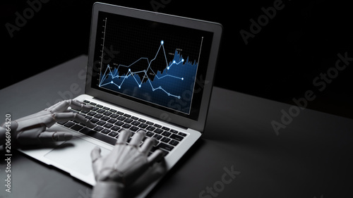 Fotografía A robotic hand operates a laptop, showcasing financial graphs and data trends against a dark backdrop, symbolizing technology and analytics evolution in finance