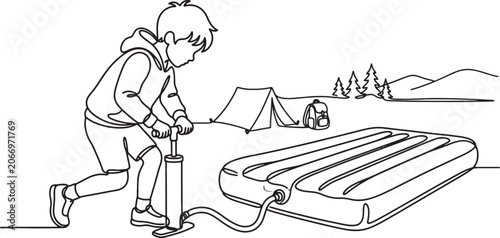 Obraz na płótnie Boy inflating air mattress while camping in the mountains