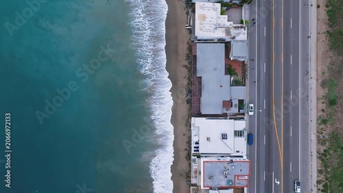 Fotografie Coastal town with houses on hillside near sandy beach