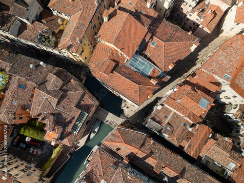 Venetian old city historic district with tiled roofs and narrow canals on sunny day, Venice, Italy