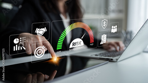 Tableau sur toile Business professional analyzing risk management metrics with digital interface showing levels of risk and business icons in modern office environment