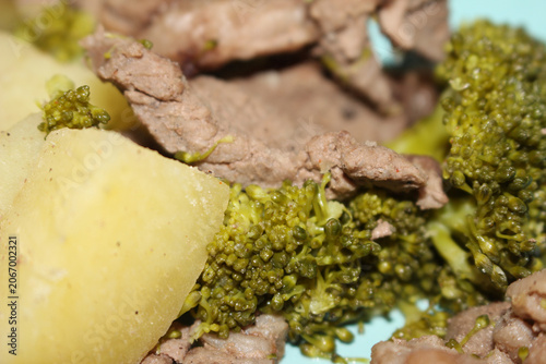 Close up of healthy meal. Broccoli sweet potato and meat dish. Nutritious fitness food details. Details of the meal made with broccoli, sweet potato and meat.
