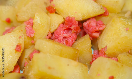 Cooked sweet potato cubes with shredded sausage. Homemade rustic dish of sweet potato and meat. chopped sweet potato with sausage. Sweet potato and shredded sausage.