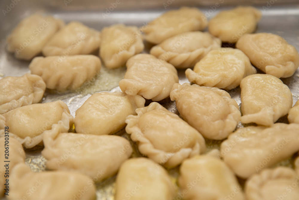 Fototapeta premium Traditional Ukrainian varenyky dumplings with butter on a metal tray, top view close-up