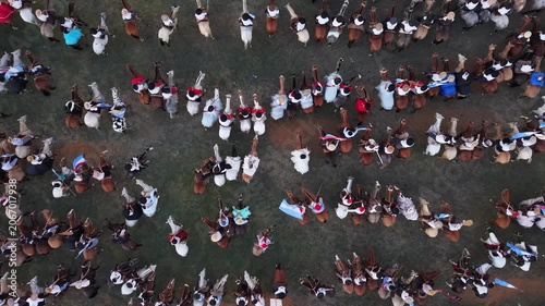 Gauchos montando caballos en fiesta popular rural vistos desde el aire, tradición ecuestre y cultura argentina