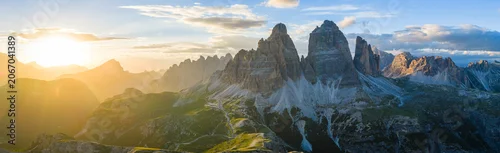 Panel kuchenny z motywem Panoramic view of Tre Cime di Lavaredo glowing in golden sunset light in the Italian Dolomites. Dramatic alpine landscape with rugged peaks, winding trails and breathtaking scenery.