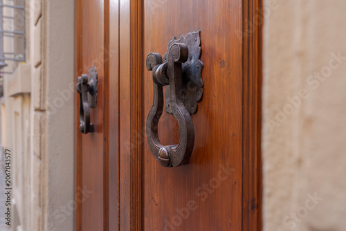 Old wooden door featuring ornate antique door knocker in Florence