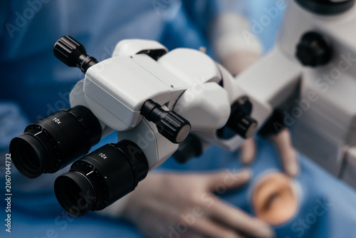 Quadro su tela Professional operating microscope prepared for cataract surgery with a patient in the background