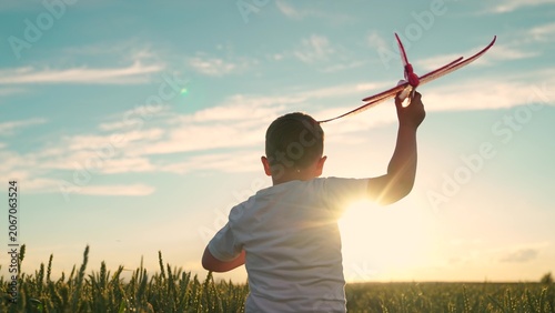 Fotografía Child plays with toy airplane, sky