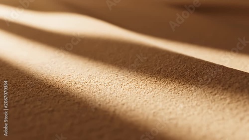 Sunlit desert sand ripples with diagonal long shadows.