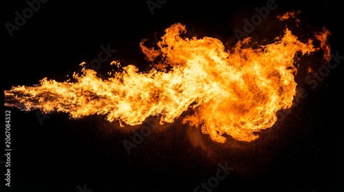 Canvas Print A horizontal jet or stream of intense orange and yellow fire shooting across a dark background