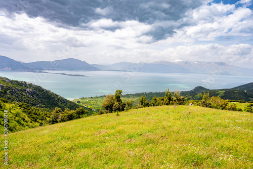 This image showcases Lake Eğirdir in Isparta, Turkey, surrounded by mountainous terrain and greenery.The area is known for natural beauty, including viewpoints from surrounding hills like Karatepe.Vis