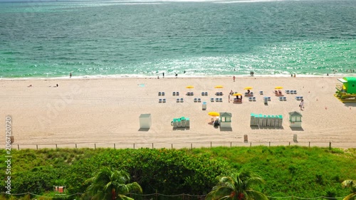 Top view of Atlantic Ocean beach with people and umbrellas seen from hotel balcony in Miami Beach. USA.