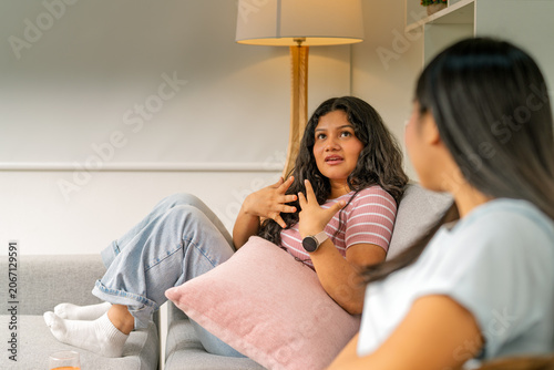 Friends talking on couch sharing home discussion